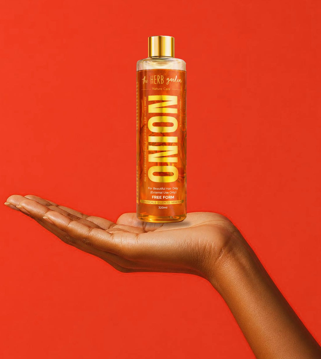 A bottle of Herb Garden Onion Hair Oil on an open palm