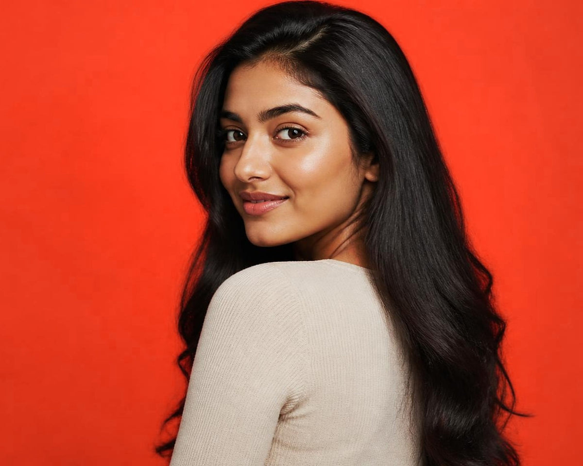 A woman with long dark hair looking over her shoulder